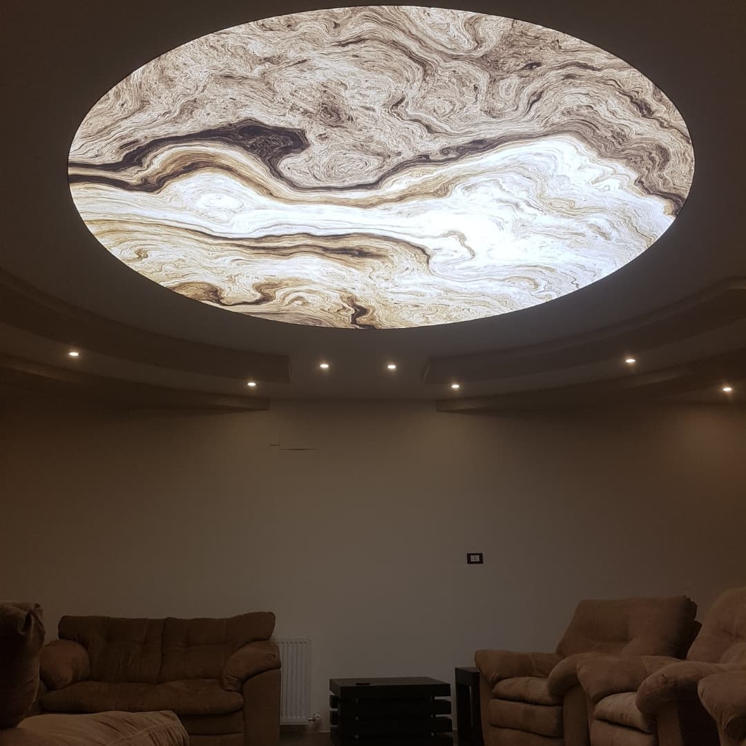 Large oval backlit ceiling with a marble-effect print above a lounge