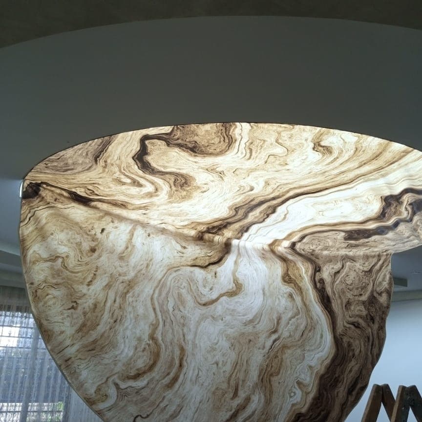Round backlit ceiling feature printed with a flowing marble pattern