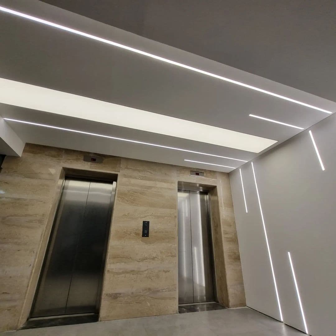 Lift lobby with angled linear lights across the ceiling