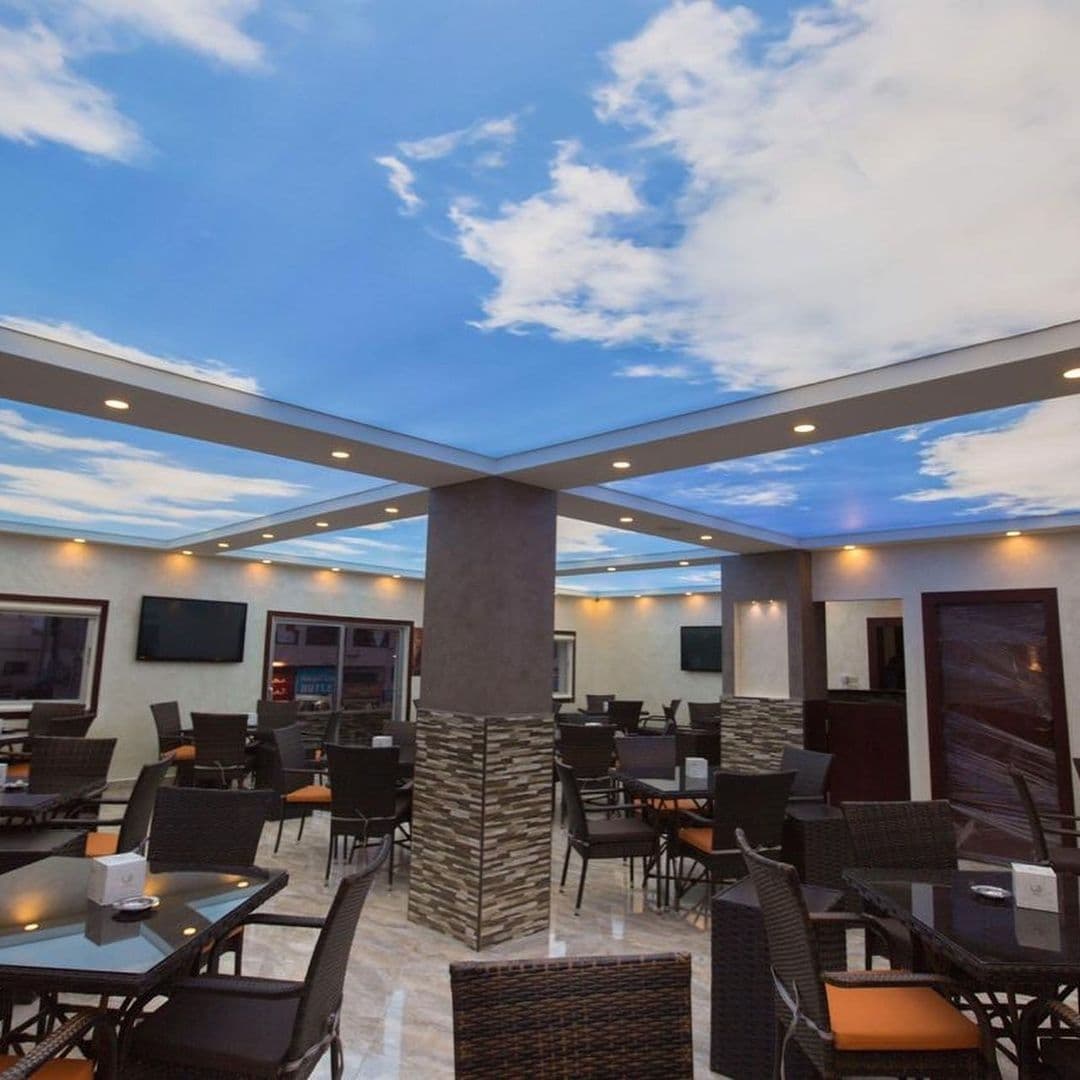 Dining area with printed sky ceiling panels around a central column