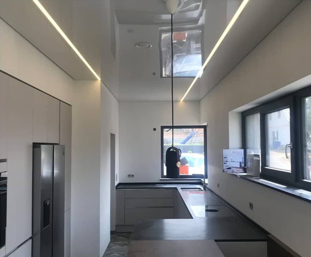 Narrow kitchen with a satin ceiling and recessed light lines