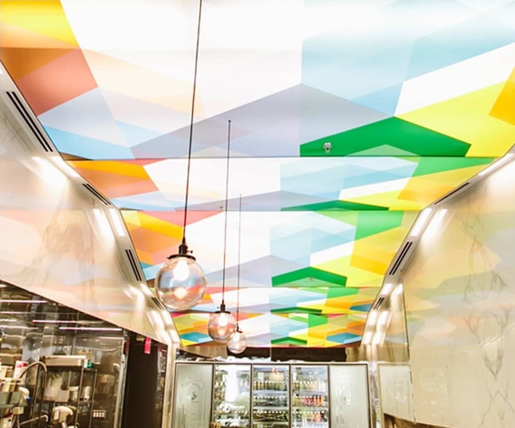 Store aisle with a colourful geometric printed ceiling