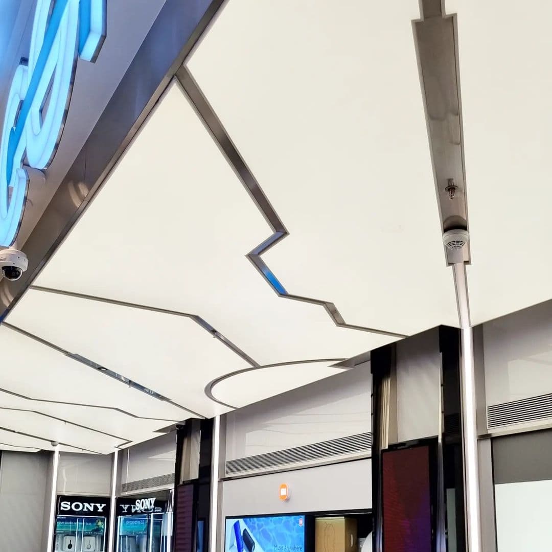 Mall storefront ceiling with stepped curved stretch ceiling forms