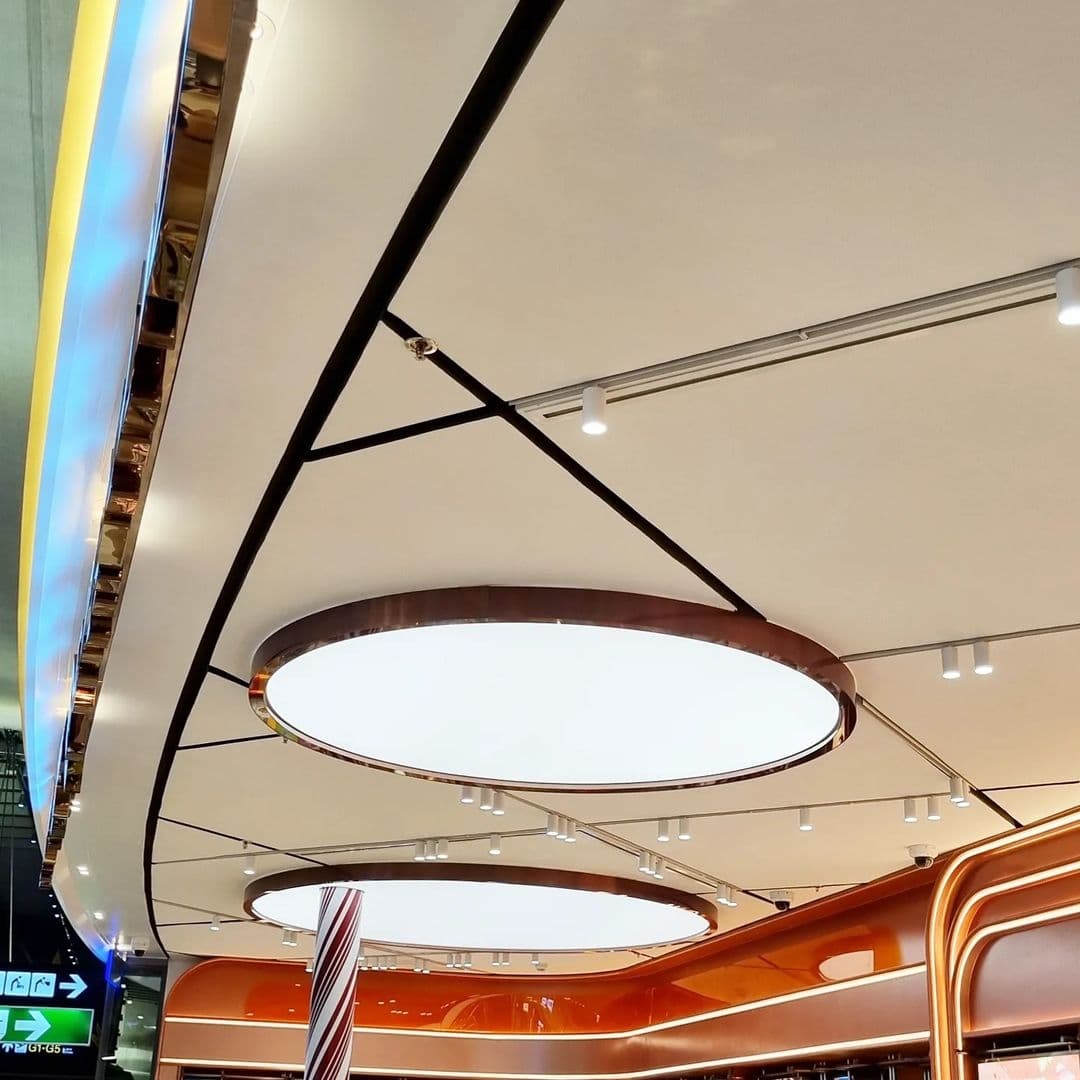 Mall ceiling with circular backlit forms and curved bulkheads