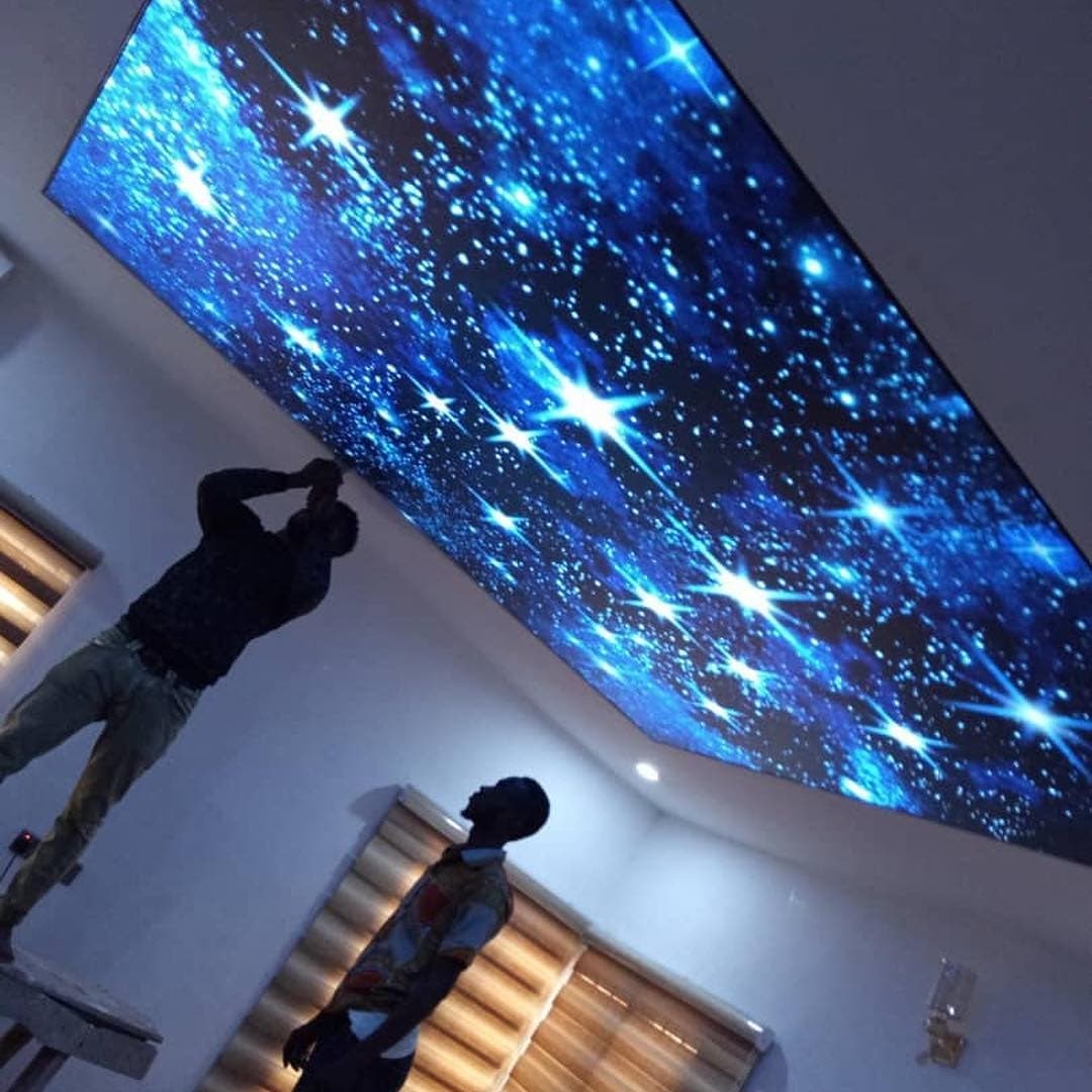 Installers fitting a printed galaxy stretch ceiling