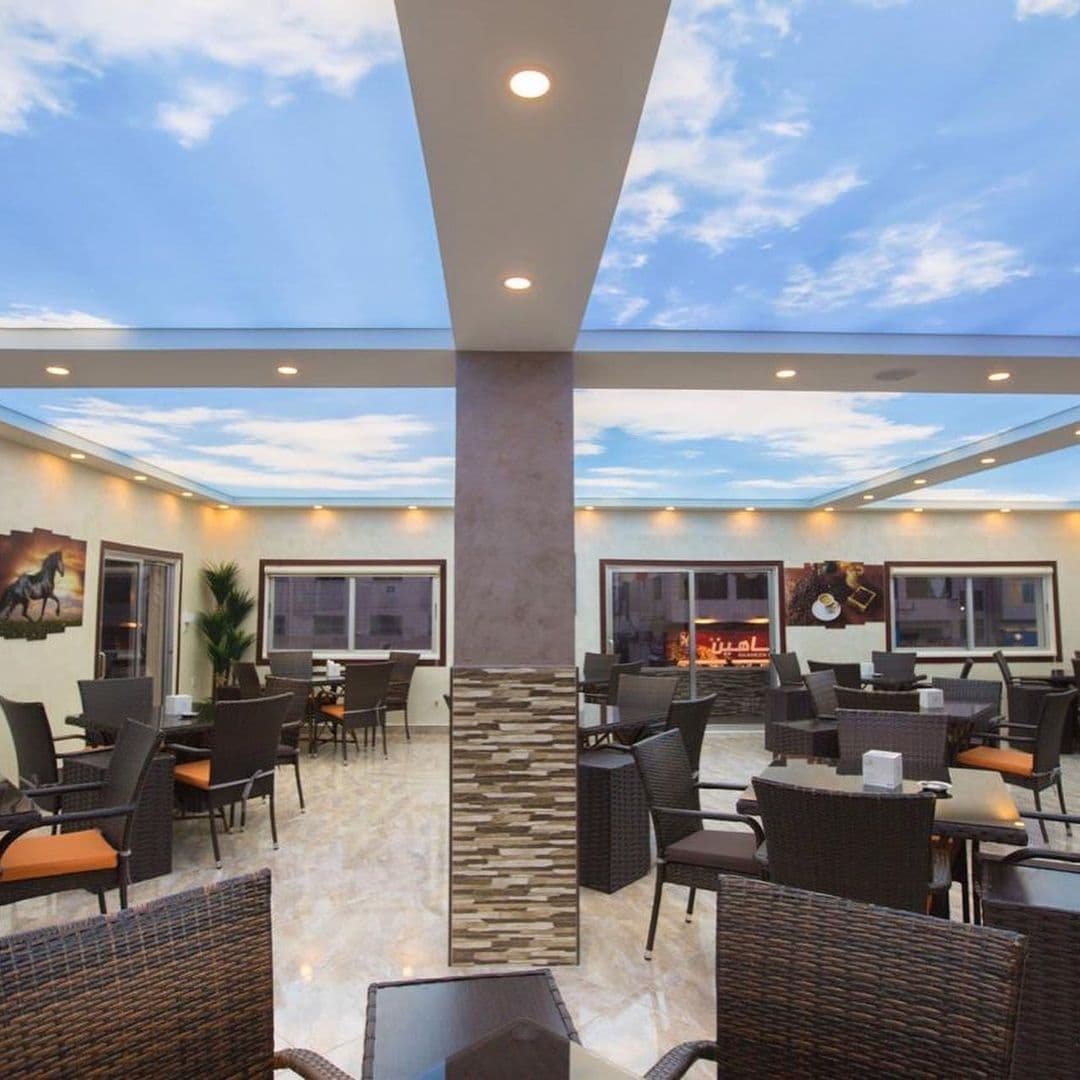 Café seating area under a printed blue-sky stretch ceiling