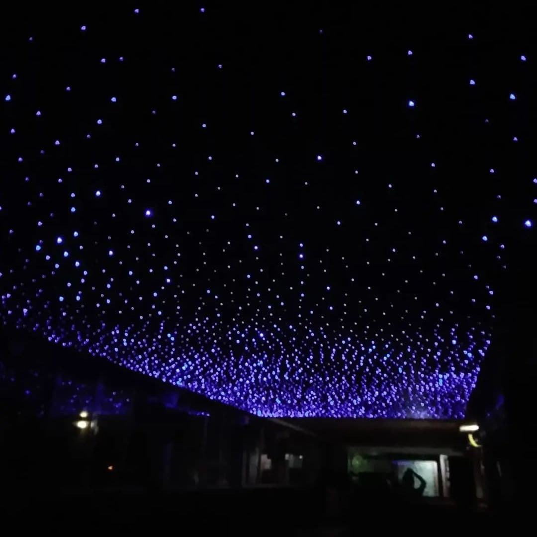 Fibre-optic starry ceiling glowing in a darkened room