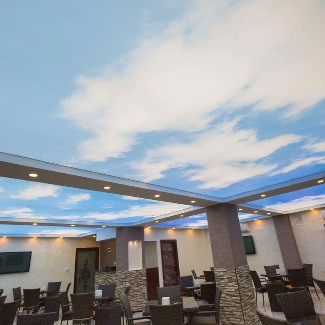 Wide view of a café with a continuous printed sky ceiling