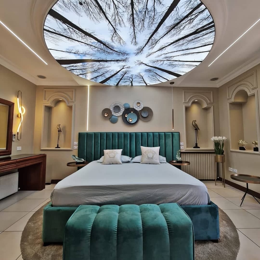 Bedroom with a circular printed ceiling showing trees reaching into the sky