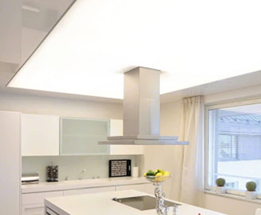 Bright kitchen with a smooth white matte stretch ceiling around the hood