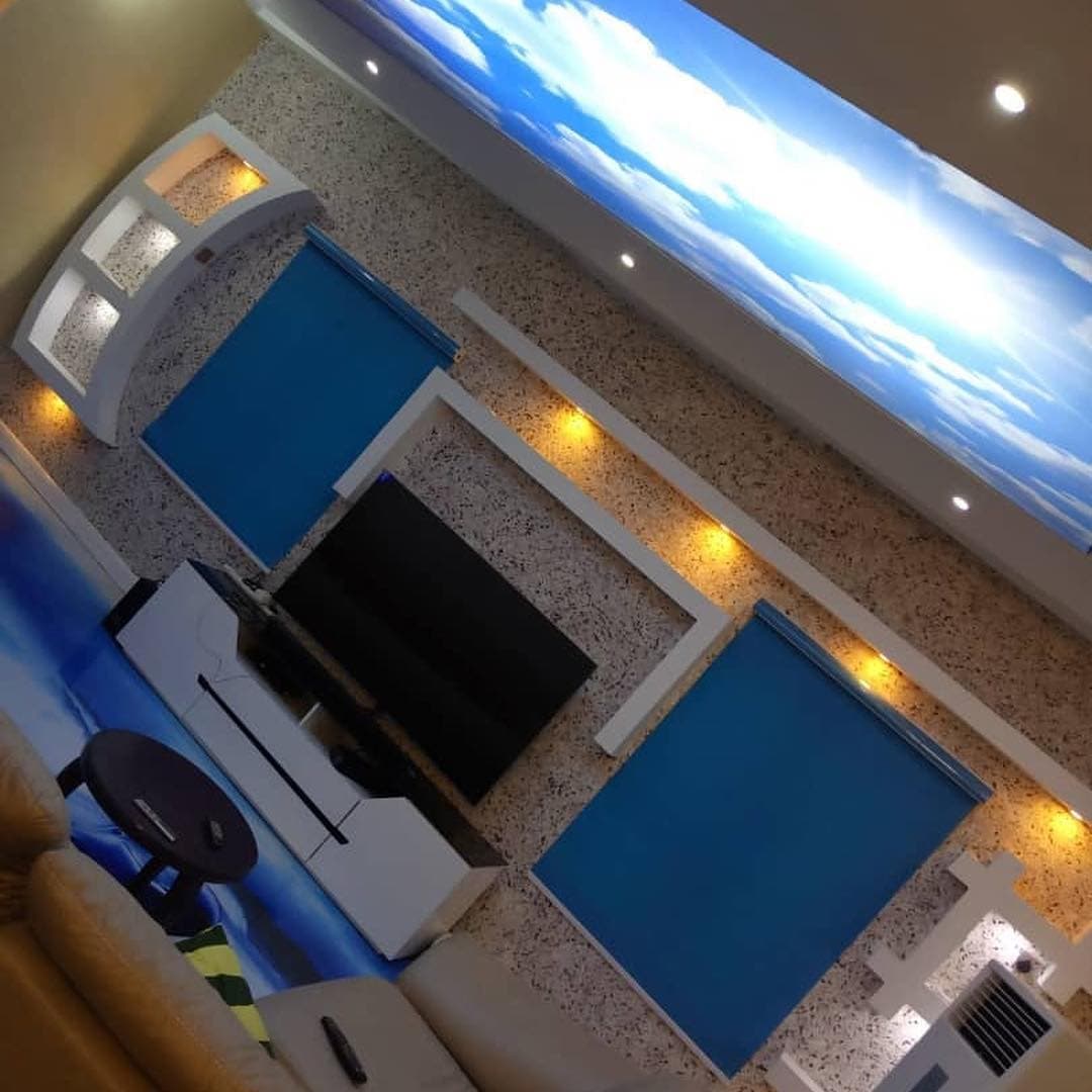 Living room TV wall beneath a printed sky ceiling